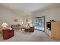Comfortable living room with neutral carpet, sliding glass doors, and ample seating at 2851 S Valley View Blvd # 1196, Las Vegas, NV 89102