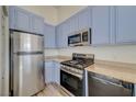 Kitchen showcasing stainless steel appliances, dishwasher, and plentiful blue cabinets at 3318 N Decatur Blvd # 2129, Las Vegas, NV 89130
