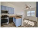 An updated kitchen featuring stainless steel appliances, blue cabinets and luxury vinyl plank flooring at 3318 N Decatur Blvd # 2129, Las Vegas, NV 89130