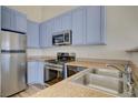 Modern kitchen boasts stainless steel appliances, granite counters, and blue cabinets at 3318 N Decatur Blvd # 2129, Las Vegas, NV 89130
