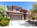 Two-story home featuring a tile roof, stone accents, a two-car garage, and desert landscaping at 3408 Livia Ave, North Las Vegas, NV 89031
