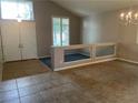 Open-concept room with a high ceiling, tile floors, and a pony wall overlooking a lower room at 4121 Erinbird Ave, North Las Vegas, NV 89084
