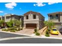 Two-story home shows desert landscaping, paver driveway to a two car garage and a serene blue sky overhead at 44 Moon Hill Dr, Henderson, NV 89011