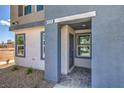 Close-up of a home's entrance, featuring textured walls and a stylish front door with an address marker at 5004 Fern Mesa Ave # Lot 137, Las Vegas, NV 89139