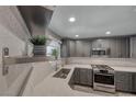 The kitchen offers a stainless steel sink, oven, microwave, quartz countertops, and gray cabinets at 5018 S Rainbow Blvd # 202, Las Vegas, NV 89118