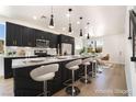 Modern kitchen with sleek black cabinets, stainless appliances, a large island, and stylish pendant lighting at 529 Fork Mesa Ct, Henderson, NV 89015