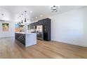 Open concept kitchen features dark cabinets, stainless steel appliances, a center island, and light flooring at 529 Fork Mesa Ct, Henderson, NV 89015