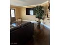 Cozy living room featuring a large television, plant, and dark wood floors at 5516 Coyote Falls Ct, Las Vegas, NV 89131