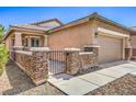 Exterior view showcasing the decorative stone facade and gated entrance leading to the front door at 5960 Wheat Penny Ave, Las Vegas, NV 89122