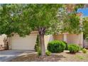 Inviting home featuring a well-maintained lawn, mature trees, and an attached two-car garage at 7924 Horn Tail Ct, Las Vegas, NV 89131