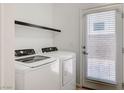 Bright laundry area with full-size washer and dryer, and an exterior door with window at 8056 Haywood Estate Ave, Las Vegas, NV 89113
