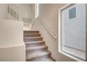 Carpeted stairs with white walls and a side window leading to upper floors at 8056 Haywood Estate Ave, Las Vegas, NV 89113