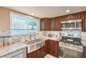 Updated kitchen features stainless steel appliances, granite countertops, and a farmhouse sink at 824 Schooner Dr, Henderson, NV 89015