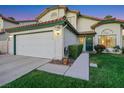 Inviting home featuring a two-car garage and lush green lawn at 8388 Brad Oaks Cir, Las Vegas, NV 89123