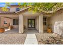 Inviting front porch with double doors, decorative pots, and low maintenance landscaping at 8723 Melissa Meadows St, Las Vegas, NV 89131