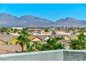 A panoramic view of mountains over the rooftops and palms of a neighborhood at 9050 W Tropicana Ave # 1075, Las Vegas, NV 89147