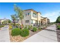 Two-story townhome featuring sidewalks, tidy landscaping, and clear skies at 1125 Meadow Sparrow Pl, Henderson, NV 89011