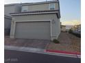 Attached two-car garage featuring brick driveway and desert landscaping at 1145 Belton Lake Ave, North Las Vegas, NV 89086