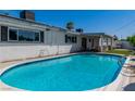 Backyard with private pool, patio area, and lush greenery, perfect for outdoor relaxation and entertaining at 1679 Raindance Way, Las Vegas, NV 89169