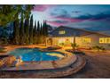 A backyard featuring a large pool with diving board surrounded by mature trees and a seating area at 1808 Piccolo Way, Las Vegas, NV 89146