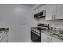 Close-up of kitchen with granite counters and stainless stove and microwave at 205 E Harmon Ave # 112, Las Vegas, NV 89169