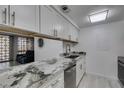 A clean galley kitchen with stainless appliances, granite countertops and white cabinets at 205 E Harmon Ave # 112, Las Vegas, NV 89169