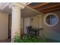 Covered patio offers an outdoor seating area with charming pillars and a round window at 2874 Tori Way, Henderson, NV 89074