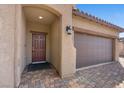 Close-up of a front door with brick-paved driveway, and a three-car garage at 3708 Fuselier Dr, North Las Vegas, NV 89032