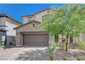 Two-story home with desert landscaping, charming shutters, and a spacious two-car garage at 387 Larksong Ave, Henderson, NV 89011