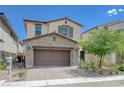 Two-story home featuring desert landscaping, a two-car garage, and beautiful exterior accents at 387 Larksong Ave, Henderson, NV 89011
