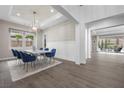 Elegant dining room features a modern chandelier, wainscoting, and access to the backyard at 4220 San Alivia Ct, Las Vegas, NV 89141