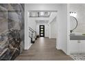 Stunning foyer with wood floors, grand staircase, decorative marble wall and modern accents at 4220 San Alivia Ct, Las Vegas, NV 89141