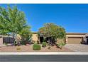 Single-story home features a mature shade tree, desert landscaping, and a two-car garage at 4260 Helena Cove Ct, Las Vegas, NV 89129