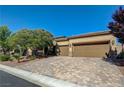 Attractive single-story home features three-car garage, desert landscaping, and long paver driveway at 4260 Helena Cove Ct, Las Vegas, NV 89129