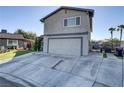 Two-story home featuring a two-car garage, desert landscaping, and a long driveway at 4474 Dawley Ct, Las Vegas, NV 89104