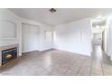 Spacious living room featuring neutral tile flooring, a fireplace, and white walls at 4730 E Craig Rd # 1115, Las Vegas, NV 89115