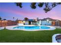 Backyard featuring a sparkling pool, well-maintained lawn, and outdoor grilling area at 4764 Lana Dr, Las Vegas, NV 89121