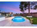 Backyard showcasing a kidney-shaped pool with ample patio space and lush artificial grass at 4764 Lana Dr, Las Vegas, NV 89121