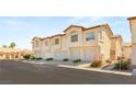 Townhome featuring multi car garage, desert landscaping and beige stucco at 4830 Grey Wolf Ln # 104, Las Vegas, NV 89149