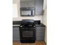 This is a kitchen with black appliances, grey cabinets, and tile flooring at 4910 Elizabeth St, Pahrump, NV 89048