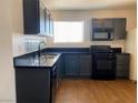 This is a kitchen with black appliances, grey cabinets, and tile flooring at 4910 Elizabeth St, Pahrump, NV 89048
