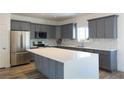 Stylish kitchen featuring gray cabinets, stainless steel appliances, and a large island with quartz countertops at 5400 E Grain Mill Rd, Pahrump, NV 89061