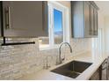 Modern kitchen sink with stylish backsplash tile and a scenic view of the mountains outside the window at 5400 E Grain Mill Rd, Pahrump, NV 89061
