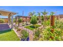 Beautiful backyard with green grass, brickwork, pergola, and several bushes and trees at 5429 Blinding Lights St, North Las Vegas, NV 89081