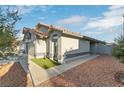 Side view of a stucco house with tile roof and low-maintenance desert landscaping at 5553 Super Bowl Dr, Las Vegas, NV 89110