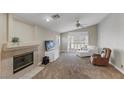 Cozy living room featuring a fireplace, ceiling fan and sliding glass doors at 5553 Super Bowl Dr, Las Vegas, NV 89110