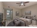 Comfortable bedroom featuring a ceiling fan, neutral walls, and access to the bathroom with a vanity sink at 5710 E Tropicana Ave # 1216, Las Vegas, NV 89122