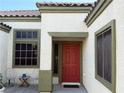Close-up of the vibrant red front door with stylish green trim and desert landscaping at 6617 Johnny Love Ln, North Las Vegas, NV 89086