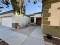 Inviting front porch with seating area, a white garage door, and a desert landscape at 6617 Johnny Love Ln, North Las Vegas, NV 89086