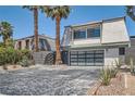 Modern home with glass garage door and unique desert landscaping, offering curb appeal and modern design at 778 Vegas Valley Dr, Las Vegas, NV 89109